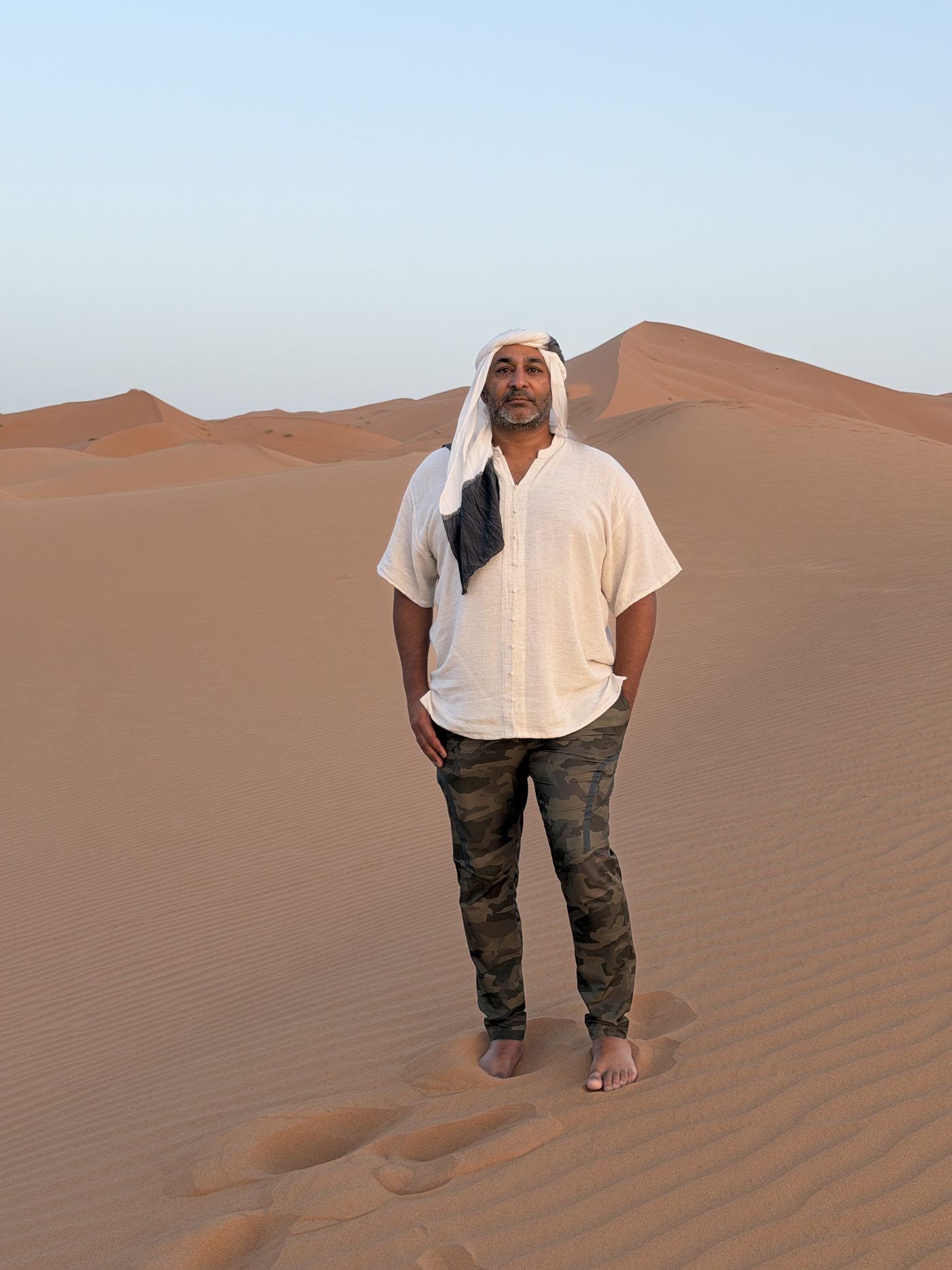 Peter Johal standing on a dune in the Sahara